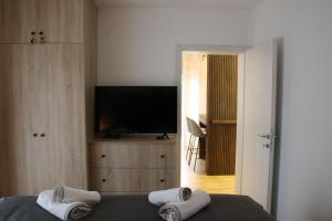 a bedroom with a television and a bed with towels at W Apartman in Vrnjačka Banja