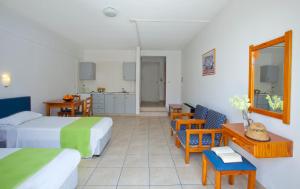 a hotel room with two beds and a table and chairs at Paloma Hotel Apartments in Ayia Napa