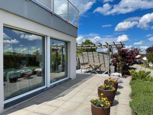 eine Terrasse mit Topfpflanzen und einem Tisch in der Unterkunft Belair Beinwil - B&B in Beinwil