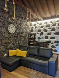 a living room with a couch and a stone wall at Casa Leon in Tejeda