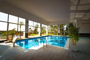 a swimming pool in a building with a large window at Kampaoh Costa Blanca in Torre de la Horadada