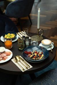 a table topped with plates of food and drinks at Altstadthotel Weißes Kreuz - In der Fußgängerzone in Innsbruck