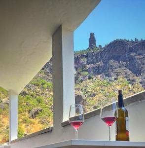 twee glazen wijn zittend op een richel met een raam bij Casa Leon in Tejeda