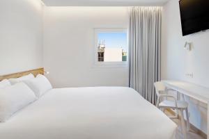 a white bedroom with a bed and a desk and a window at B&B HOTEL Porto Expo Aeroporto in Matosinhos +22 photos