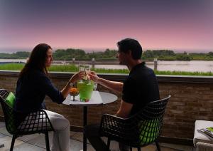 een man en een vrouw aan een tafel met drankjes bij Scheldeoever in Temse