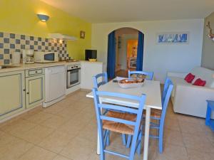 a kitchen and living room with a table and chairs at La Côte Bleue in Sainte-Lucie de Porto-Vecchio