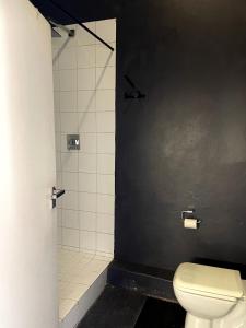 uma casa de banho com um WC e um chuveiro em Modern city apartment in Johannesburg - Maboneng em Joanesburgo