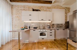 Curcumelli Luxury Suites - ΚΟΡΚΥΡΑ في مدينة كورفو: مطبخ بأدوات بيضاء وجدار من الطوب