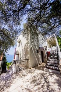 a large building with stairs next to the ocean at Apartment SuperSeaView in Sutomore