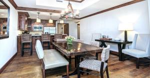 Ritz Carlton Residence #5 Condo في فيل: مطبخ وغرفة طعام مع طاولة وكراسي خشبية