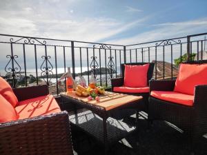 einen Balkon mit Stühlen und einem Tisch mit Obst darauf in der Unterkunft Holiday Home Villa Bella in Vrsar