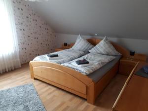een slaapkamer met een houten bed met 2 kussens bij Haus konni in Knuftenge