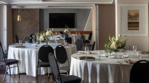 una habitación con mesas y sillas con manteles blancos en Hyatt Regency Cape Town en Ciudad del Cabo