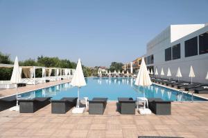 a large swimming pool with chairs and umbrellas at Ramada by Wyndham Istanbul Sile in Şile