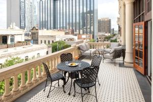 a patio area with chairs, tables, and a balcony at The Driskill, in The Unbound Collection by Hyatt in Austin