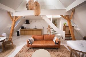 a living room with a couch and a staircase at Nobel Houses & Lofts in Ballum