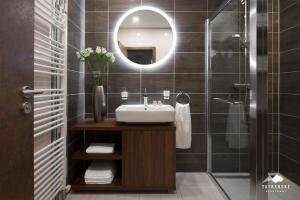 a bathroom with a sink and a mirror at Luxusný Apartmán Hrebienok Resort - Tatranské Apartmány in Vysoke Tatry - Stary Smokovec