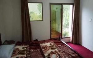 - une chambre avec un lit et une grande fenêtre dans l'établissement Hotel Pine View & Restaurant, à Bālākot