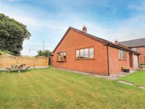 a red brick house with a picnic table in the yard at Sandmartins in Chester