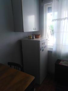 cocina con nevera blanca y ventana en Емил, en Velingrad