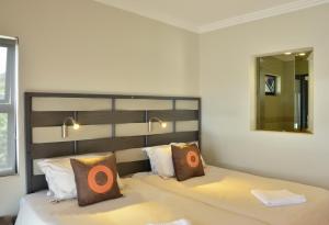 um quarto com uma cama grande e um espelho em Greenfire Dolphin Coast Lodge em Umdloti