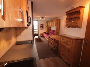 a kitchen with wooden cabinets and a table and a couch at Appartement Les Saisies, 3 pièces, 6 personnes - FR-1-293-80 in Les Saisies