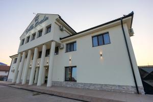 a white building with columns on a street at Hotel Villa Ovidiu in Drobeta-Turnu Severin
