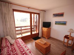 a living room with a couch and a tv and a window at Studio Les Saisies, 1 pièce, 4 personnes - FR-1-293-146 in Les Saisies