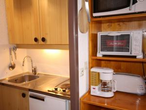 una pequeña cocina con fregadero y microondas en Studio Les Saisies, 1 pièce, 4 personnes - FR-1-293-173, en Les Saisies