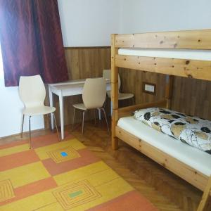 een kamer met 2 stapelbedden en een tafel en stoelen bij Elza Vendégház in Sárospatak