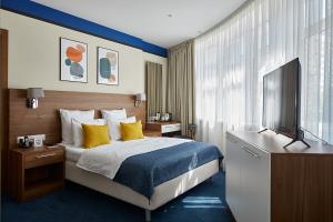 um quarto de hotel com uma cama e uma televisão de ecrã plano em Select Hotel Paveletskaya em Moscou