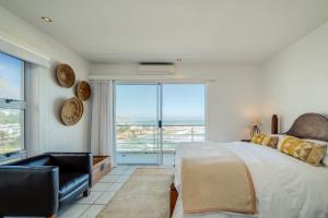 sypialnia z łóżkiem i dużym oknem w obiekcie Camps Bay Terrace Penthouse w Kapsztadzie