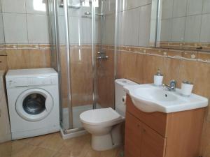 ein Badezimmer mit Toilette, Waschbecken und Waschmaschine in der Unterkunft Helios Studio Drago in Costa Del Silencio