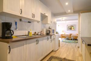 a kitchen with white cabinets and a dining room at W Ciemno in Ciemno
