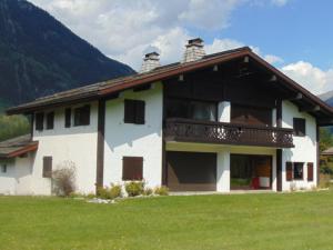 Cette grande maison blanche dispose d'un balcon dans un champ. dans l'établissement Appartement Chamonix-Mont-Blanc, 3 pièces, 4 personnes - FR-1-517-38, à Chamonix-Mont-Blanc