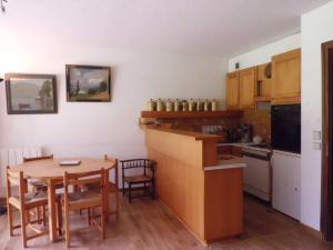 une cuisine avec une table en bois, une table et des chaises dans l'établissement Appartement Chamonix-Mont-Blanc, 3 pièces, 4 personnes - FR-1-517-38, à Chamonix-Mont-Blanc
