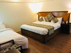 um quarto de hotel com duas camas num quarto em Parhena Cottages Bella Naran em Nārān