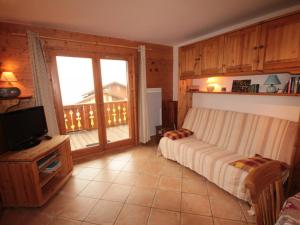1 dormitorio con cama, TV y balcón en Appartement Villard-sur-Doron, 3 pièces, 6 personnes - FR-1-293-254 en Villard-sur-Doron