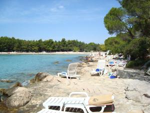 una playa con tumbonas y agua en Holiday Home Pine Villa, en Pakoštane