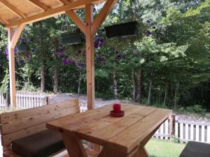 a wooden table and bench under a gazebo at Honeywood Cabin II with Private Spa in Bijelo Polje
