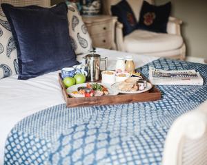 a tray of food on top of a bed at The George Inn in Barford Saint Michael