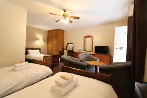 ein Hotelzimmer mit 2 Betten und einem Schreibtisch in der Unterkunft St George's Lodge, Bisley in Brookwood