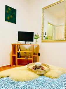 a living room with a table and a mirror at Katalin Panzió in Budapest