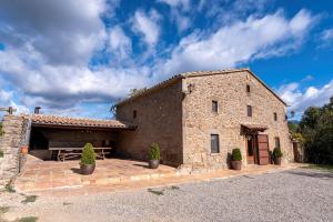 un gran edificio de piedra con una mesa de picnic delante de él en Casa Moixella en Lladurs