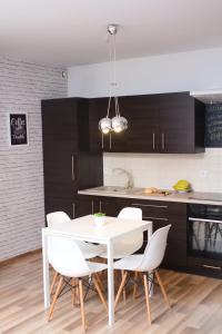 a kitchen with a white table and white chairs at Apartament Tiffany in Gdańsk