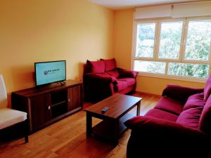 ein Wohnzimmer mit zwei Sofas und einem Fernseher in der Unterkunft HOLIDAY HOMES by del abuelo VEGADEO in Vegadeo