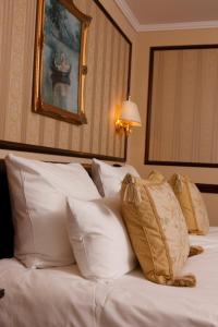 ein Hotelzimmer mit einem Bett mit weißen Kissen in der Unterkunft Hotel Villa Achenbach in Düsseldorf