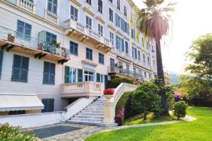 un edificio de apartamentos con escaleras y una palmera en CasaViva - Beautiful Bilo with shared pool in Genova Nervi en Génova