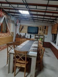 a dining room with a table and chairs and a tv at Complex Turistic Essenza in Murighiol
