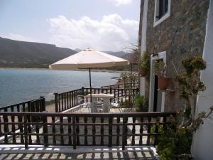eine Terrasse mit einem Tisch und einem Sonnenschirm in der Unterkunft Hiona Cottage in Palekastro
